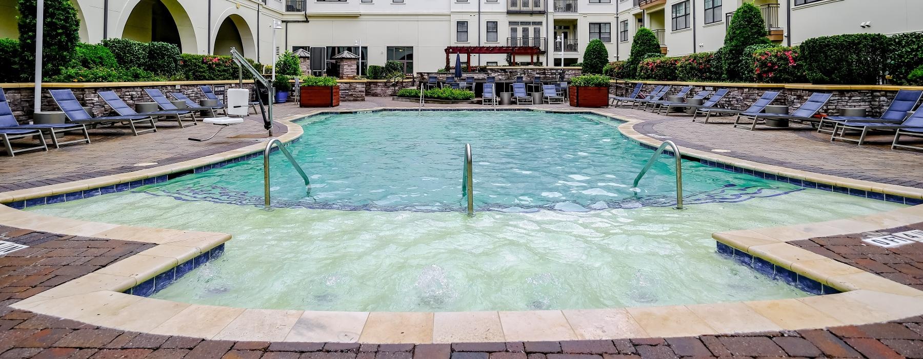 outdoor pool surrounded by lounge chairs
