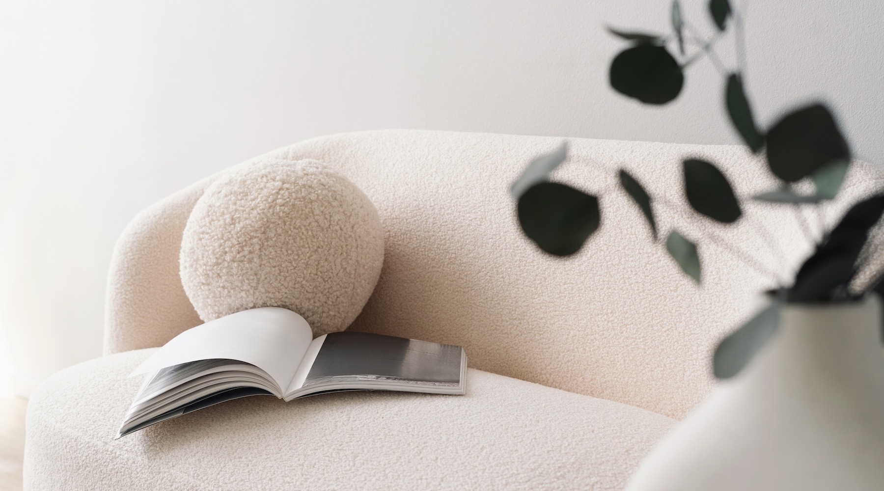 a couch with a book on it near a plant